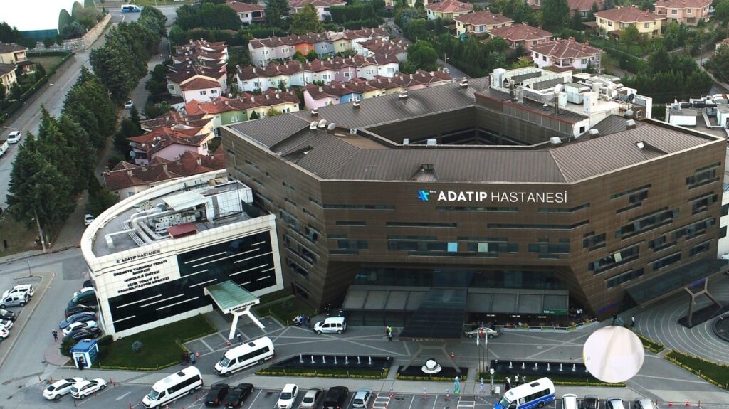 снимок клиники Özel Adatıp Hastanesi с парковкой скорых и жилым районом